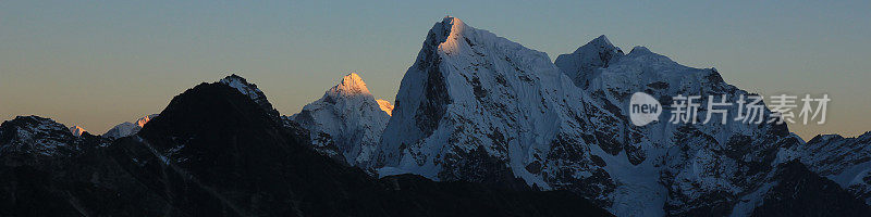 日落时分，阳光照亮了尼泊尔的Ama Dablam和Cholatse山峰。